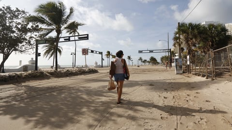 Hurricane Irma dumped water on towns and covered oceanside streets with sand in several states. Here, Amela Desanto walks along Fort Lauderdale Beach on Monday, as the storm headed inland.