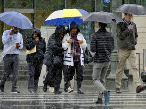 Pedestrians make their way across a street in the pouring rain in downtown Los Angeles on Wednesday, March 21, 2018. The storm came ashore on the central coast and spread south into the Los Angeles region and north through San Francisco Bay.