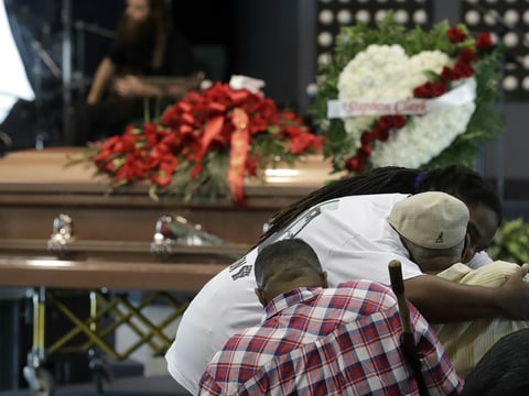 A man hugs another man before funeral services for Stephon Clark at Bayside Of South Sacramento Church, known as BOSS Church, in Sacramento, Calif., Thursday, March 29, 2018.