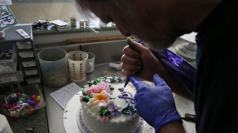 In this March 10, 2014, photo, Masterpiece Cakeshop owner Jack Phillips decorates a cake inside his store, in Lakewood, Colo.