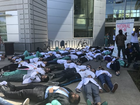 UC Davis medical students lay on the ground in a “white coat die-in” — an event organized by a national medical student organization called WhiteCoats4BlackLives.