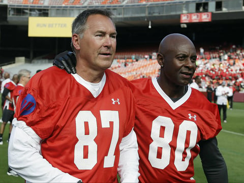 In this July 12, 2014, file photo, former San Francisco 49ers wide receivers Dwight Clark, left, and Jerry Rice, right, walk together on the field before the "Legends of Candlestick" flag football game in San Francisco. 