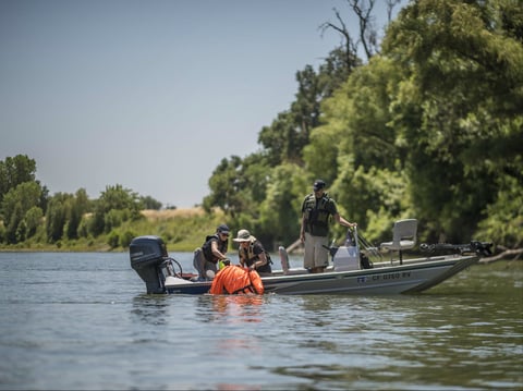 Chico State researchers watch a floating dummy in the Sacramento River. They're tracking how far and fast floating bodies travel in the hopes of helping water rescue teams narrow their search windows."