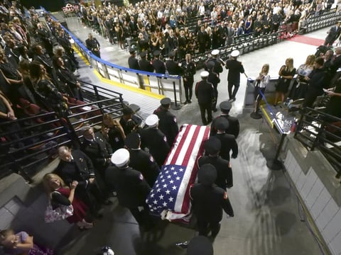 Firefighters carry the casket of Battalion Chief Matt Burchett of the Draper Fire Department into the Maverik Center during funeral services Monday, Aug. 20, 2018, in West Valley City, Utah. 