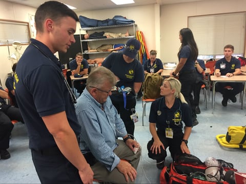 Brandon Faddis leads classmates during a simulated call as instructor Grant Goold plays the part of a patient.