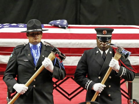 The Honor Guard stands at attention in front the casket of Battalion Chief Matt Burchett of the Draper Fire Department during funeral services Monday, Aug. 20, 2018, in West Valley City, Utah.