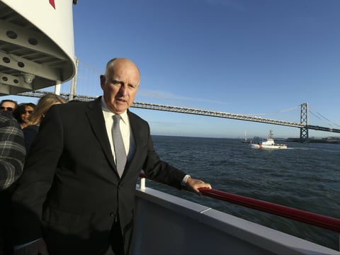 Gov. Jerry Brown walks to the bow of the high-tech battery-operated San Francisco Bay sightseeing boat, Enhydra. He signed 16 new laws aimed at easing global warming Sept. 13, 2018.
