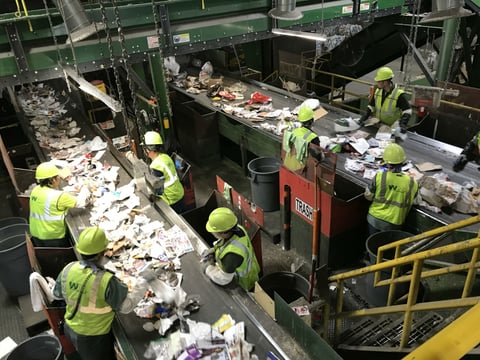 Workers at the Sacramento Recycling and Transfer Station sort through materials to separate contaminants from recyclables.