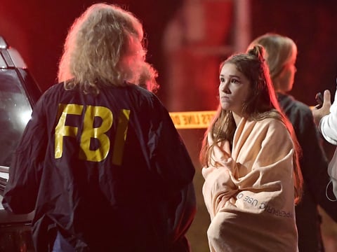 An FBI agent talks to a potential witness to the shooting at the Borderline Bar and Grill in Thousand Oaks, Calif., where a gunman opened fire inside the country dance bar on "college night."