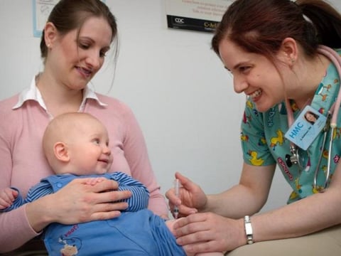 A baby receives a vaccine from a nurse. Photo by Judy Schmidt, federal Centers for Disease Control.