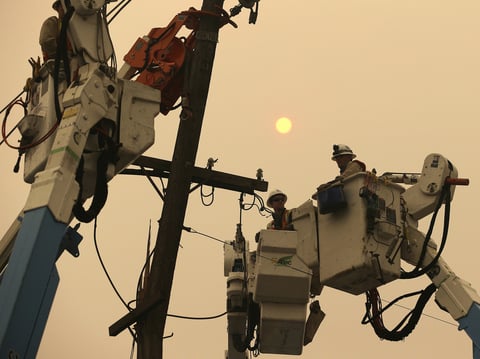 PG&E crews work to restore power lines in Paradise, Calif., after the Camp Fire destroyed much of the Northern California town.