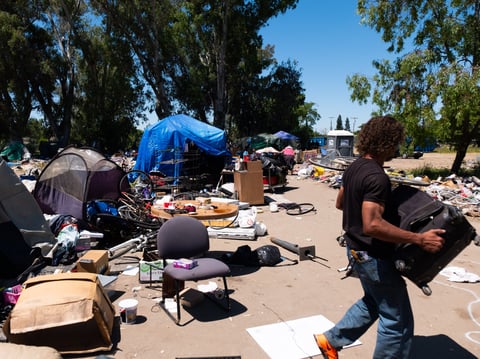 Steven Ford sorted through a friend's belongings as part of ⁦the Sacramento Sheriff's Office eviction of homeless residents on Stockton Boulevard.