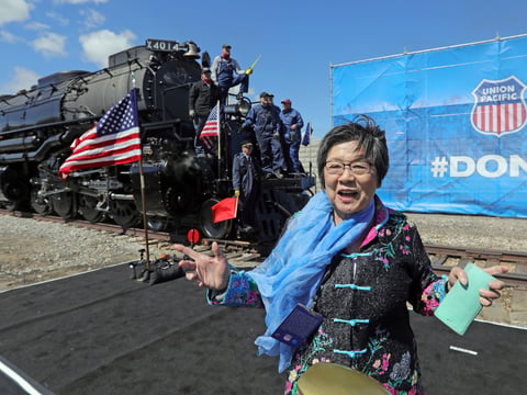 Margaret Yee, whose ancestors helped build the railroad, pose in front of the the Big Boy, No. 4014 during the commemoration of the 150th anniversary of the Transcontinental Railroad completion at Union Station Thursday, May 9, 2019, in Ogden, Utah.