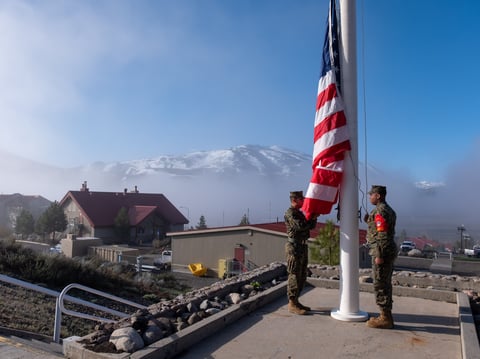 Marines stand at attention before raising the American flag at the United States Marine Corps Mountain Warfare Training Center near Bridgeport, Calif., off Highway 395.