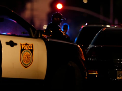 A law enforcement officer mans a barricade near a home that authorities have surrounded where an armed suspect has taken refuge after shooting a Sacramento police officer, Wednesday, June 19, 2019, in Sacramento.