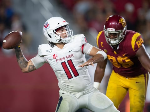 In this Sept. 31, 2019, file photo, Fresno State quarterback Jorge Reyna, left, looks to throw a pass as Southern California USC Trojans defensive lineman Christian Rector approaches during an NCAA college football game in Los Angeles.