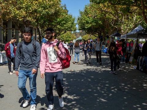 Students cross UC Berkeley on September 6, 2019. A new state survey shows two thirds of California college students struggle with the cost of housing, books and food.