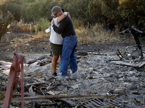 Justo and Bernadette Laos hug while looking through the charred remains of the home they rented that was destroyed by the Kincade Fire near Geyserville, Calif., Thursday, Oct. 31, 2019.