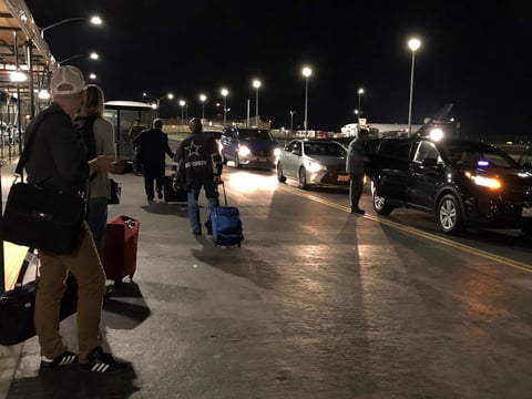 Travelers wait at the ride-share pickup location at Sacramento International Airport. Uber is allowing drivers at three California airports to set their own fares.