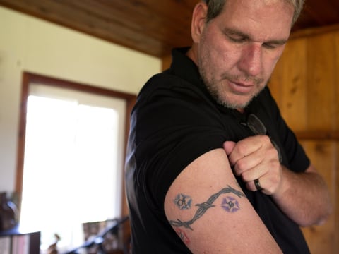 Andrew Simmons tattooed the initials of all six of his adopted children on his arm. Simmons still owes San Diego County over $13,000 for the time his son spent in juvenile hall as a teen.