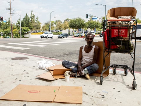 Will, a homeless man who provided his first name only, sits on a sidewalk in Los Angeles.