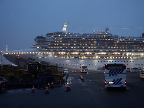 Buses arrive at Yokohama Port, near Tokyo, as the Japan Self-Defense Forces prepare to move American passengers from the quarantined Diamond Princess cruise ship on Sunday.
