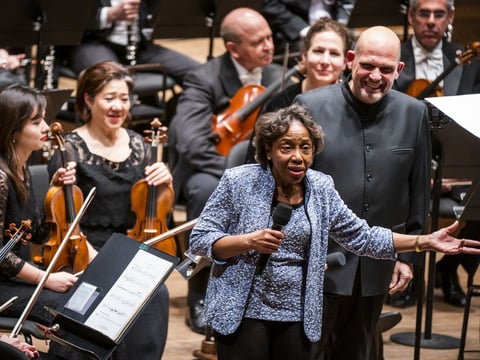 Tania León speaks at the premiere of her piece "Stride," one of 19 pieces composed by women that the New York Philharmonic commissioned to celebrate the 100th anniversary of the 19th Amendment.