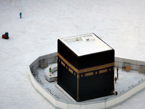 Saudi policemen and cleaning workers are seen around the Kaaba, the cubic building at the Grand Mosque, in the Muslim holy city of Mecca, Saudi Arabia, Friday, March 6, 2020.