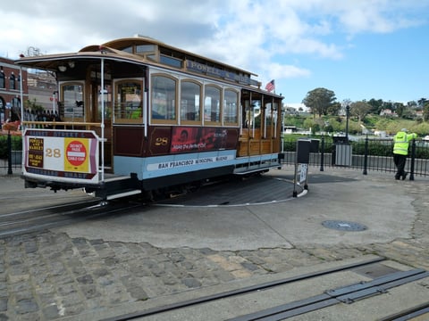 A cable car operator looks out toward the Golden Gate Bridge while standing at the near-empty Hyde Street turnaround Monday, March 16, 2020, in San Francisco.
