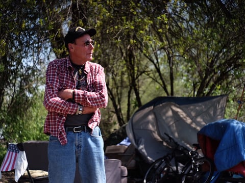 "DJ Dave," as he's known around the encampment along the American River, stands by his camp site.