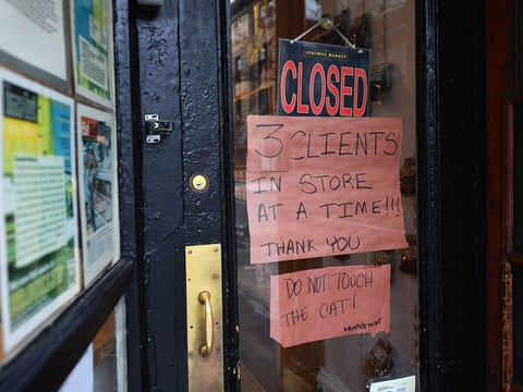 A butcher shop in the Brooklyn borough of New York shows a "Closed" sign, limiting customers to three at a time. Gov. Andrew Cuomo is ordering all nonessential businesses to close.