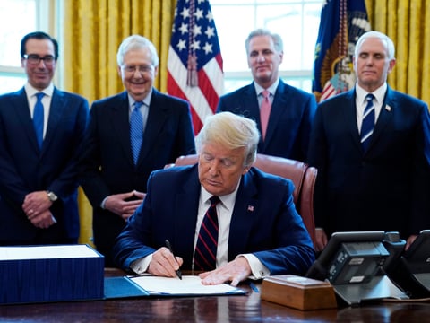 President Donald Trump signs the coronavirus stimulus relief package, at the White House, Friday, March 27, 2020, in Washington.