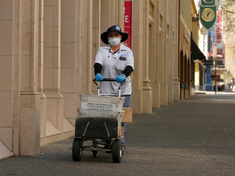 In this Wednesday, March 25, 2020 file photo, U.S Postal carrier Jasmine Yang wears a mask and gloves as preventative measures against the coronavirus, as she delivers the mail in Sacramento.