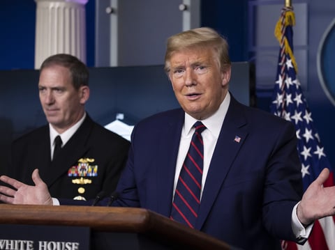 President Trump speaks about the coronavirus, as Navy Rear Adm. John Polowczyk, supply chain task force lead at FEMA, listens on Thursday at the White House.