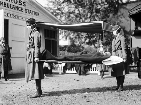 Two Red Cross nurses carry a person on a stretcher during a demonstration at the Red Cross Emergency Ambulance Station in Washington, D.C., in 1918.