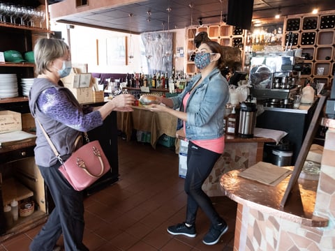 Downtown Sacramento resident Diane Luther picks up groceries and prepared food handed to her by Aioli employee Liz Suemnicht Monday May 18, 2020.