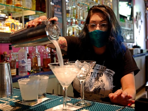 Bartender Taylor Osorio wears a face mask as she pours drinks at Centro Cocina Mexicana restaurant in Sacramento, Calif., Friday, May 22, 2020.