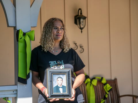 Taun Hall at home, standing next to a green ribbon, the international symbol for mental health awareness. She display the ribbons in remembrance of her son, Miles, who was killed last year by Walnut Creek police during a mental health crisis.