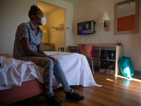 Jamie Burson sits on the bed of her motel room in Fairfield on August 4, 2020. Burson, who has been living between her car and motels since being evicted in April, said she feels unsafe at the motel and planned to move again later later that day.