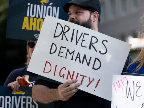 Protesters carrying signs supporting AB-5, a new law that changed the employment classification for gig workers such as Uber and Lyft drivers, in front of the California capitol on August 28, 2019.