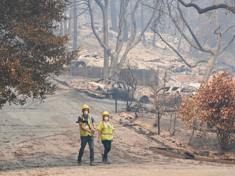 Workers with Davey Resource Group assess the damage to the trees in a neighborhood Tuesday, Aug. 25, 2020, in Boulder Creek, Calif.,after the the CZU August Lightning Complex Fire passed by.