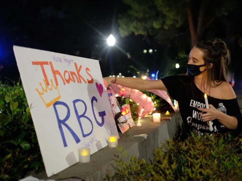 Sara Rose Thibaut of Folsom adds to a memorial for Supreme Court Justice Ruth Bader Ginsburg at the California state Capitol Saturday, Sept. 19, 2020