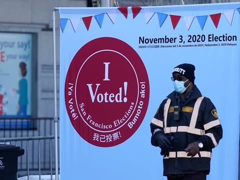 A security guard stands near an exit at a San Francisco Department of Elections voting center near City Hall in San Francisco, Tuesday, Oct. 20, 2020.