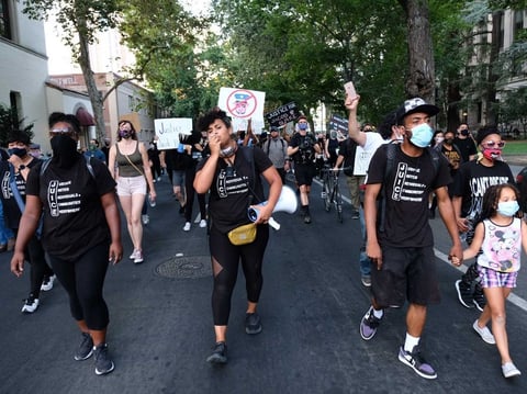 Demonstrators with JUICE Sacramento, which stands for Justice Unites Individuals and Communities Everywhere, march through downtown Sacramento August 27, 2020.