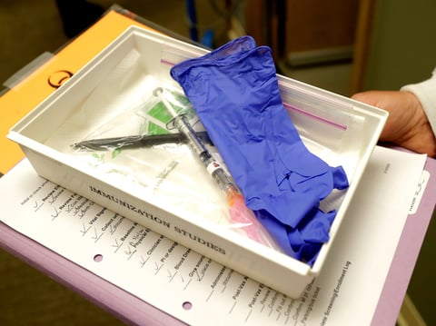 In this March 16, 2020, file photo, pharmacist Michael Witte holds a tray with a syringe containing a shot that will be used in the first clinical trial of a potential vaccine for COVID-19.