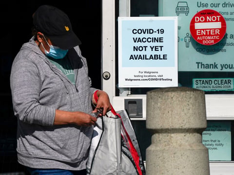A customer walks past a sign indicating that a COVID-19 vaccine is not yet available at Walgreens, Wednesday, Dec. 2, 2020, in Long Beach, Calif.