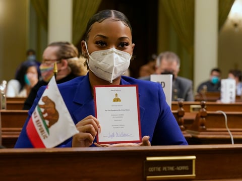 Tayte Williams a member of California's Electoral College holds up her ballot for Vice President-Elect, Sen. Kamala Harris at the state Capitol in Sacramento, Calif., Monday, Dec. 14, 2020.