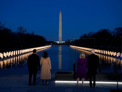 President-elect Joe Biden; his wife, Jill Biden; Vice President-elect Kamala Harris; and her husband, Doug Emhoff, listen as Yolanda Adams sings "Hallelujah" during a COVID-19 memorial, with lights placed around the Lincoln Memorial's reflecting pool