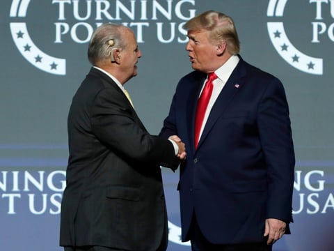 Rush Limbaugh, left, shakes hands with President Donald Trump as he introduces Trump at the Turning Point USA Student Action Summit at on Dec. 21, 2019, in West Palm Beach, Fla.