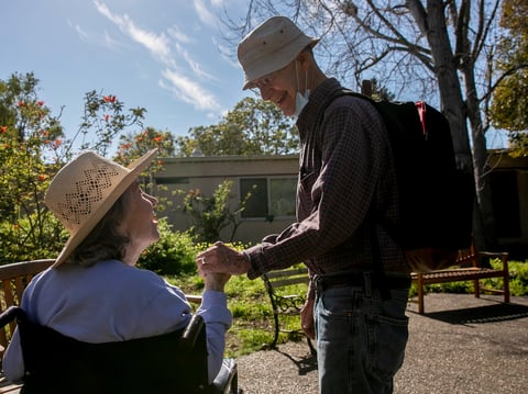 Larry Yabroff and his wife Mary greet each other during a visit at Chaparral House, a skilled nursing facility where Mary is a resident, in Berkeley on Feb. 25, 2021.
